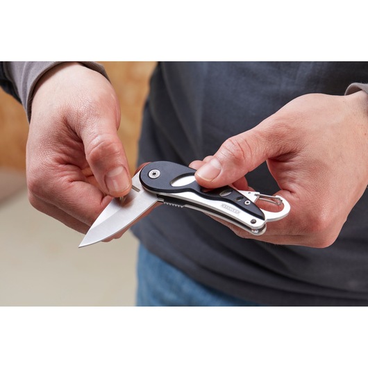 Photo of STANLEY 0-10-254 folding utility knife with black handle and carabiner in hand, blade extended.