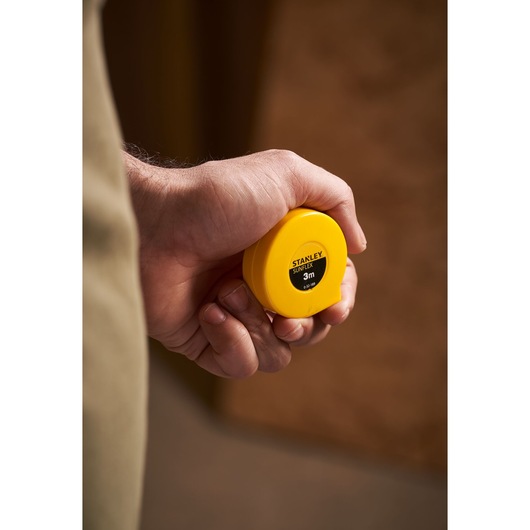 STANLEY 0-32-189 yellow tape measure held in hand, close-up photography.