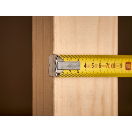 STANLEY 0-33-198 tape measure extended across wooden plank, close-up angle.