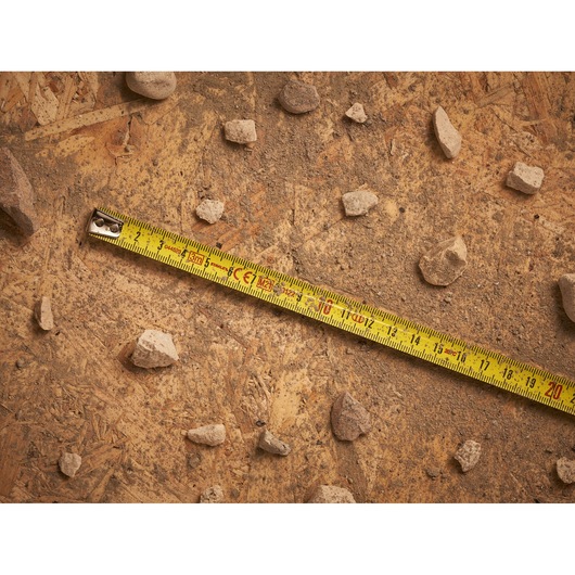 STANLEY 0-33-218 tape measure photography on a dusty wooden surface with scattered rocks.