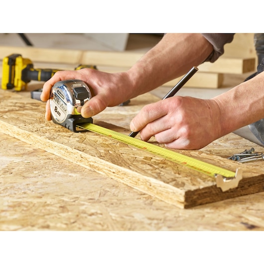 Stanley 0-33-892 tape measure for woodworking, shown measuring on plywood surface.