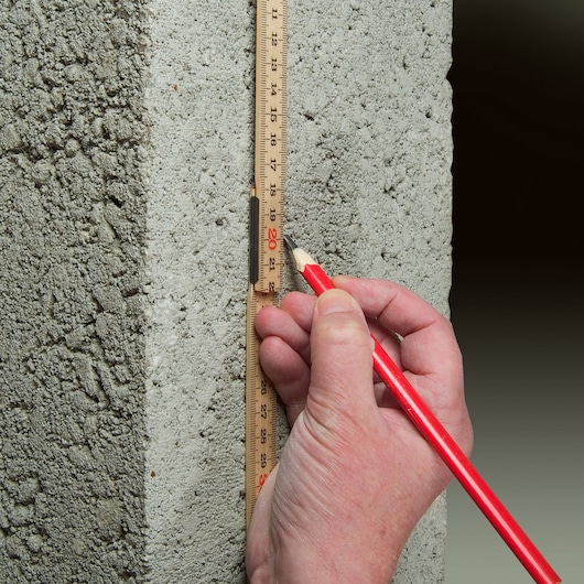 STANLEY 0-35-101 folding ruler measuring concrete wall, red pencil marking on ruler.