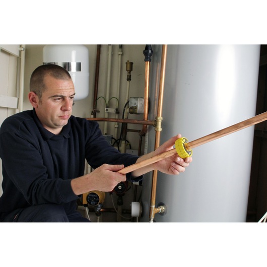 Photo of STANLEY 0-70-446 pipe cutter tool being used on copper pipe in plumbing setting.
