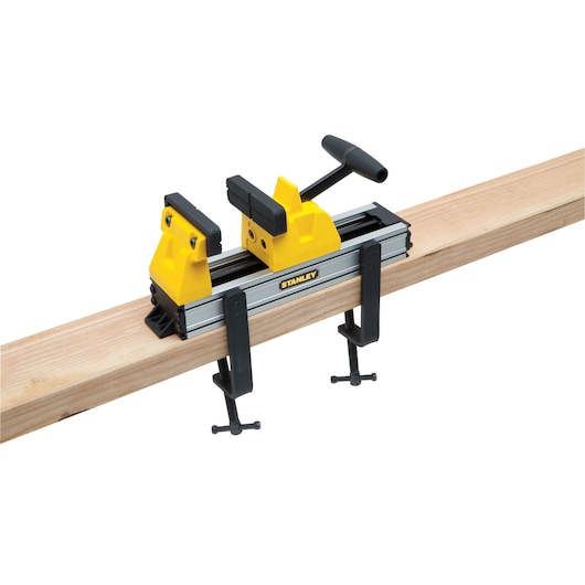 Photo of STANLEY 0-83-179 yellow and black portable vice clamped to a wooden beam, front angle.