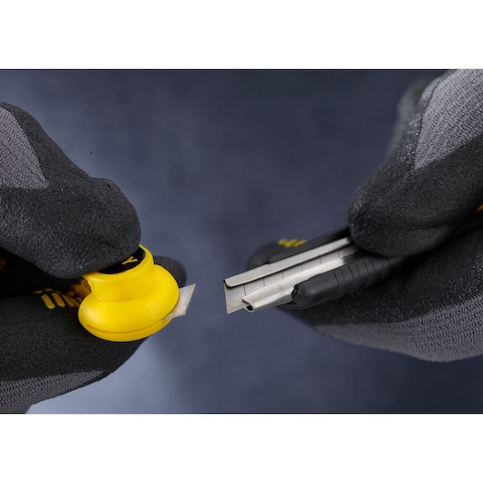 STANLEY 1-10-409 utility knife blade snapper held in gloved hands, close up, photography.