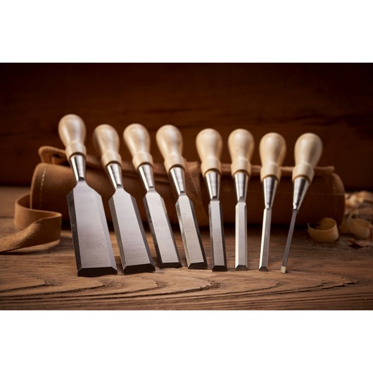 STANLEY 1-16-793 wood chisel set with eight chisels, wooden handles, and a brown leather roll, side angle.