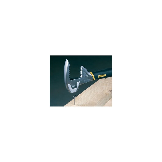 STANLEY 1-55-119 adjustable wrench with black and yellow handle gripping a nail in wood, side angle.