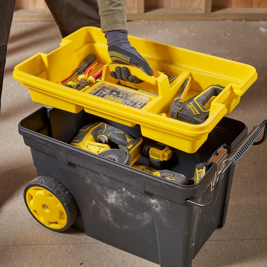 STANLEY 1-92-904 rolling toolbox with yellow tray, assorted hand tools, and power tools, photographed from above.