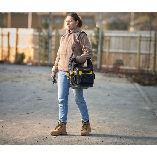 Photo of STANLEY 1-93-952 tool bag with shoulder strap carried by person in outdoor worksite.