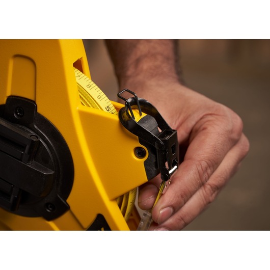 STANLEY 2-34-772 measuring tape close-up with yellow casing held by hand, product photography.
