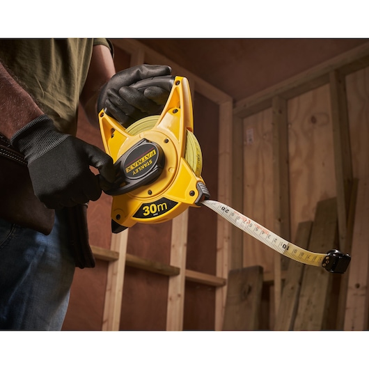 Photo of STANLEY 2-34-814 30m open reel tape measure in use at construction site.