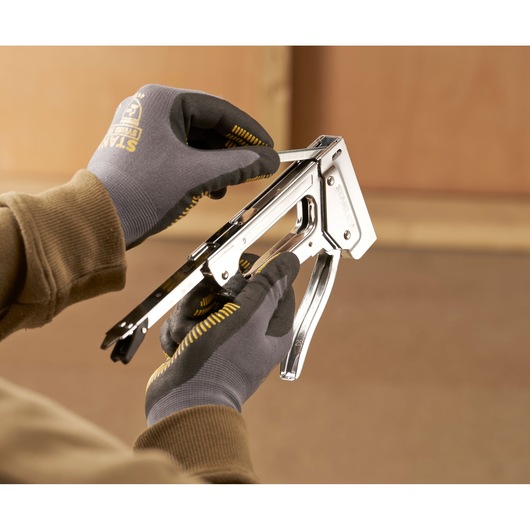 Stanley 6-TR45 photography of person loading staples into chrome staple gun.