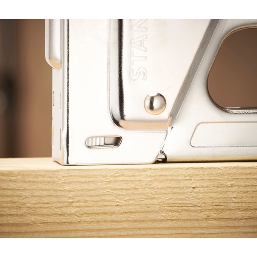 Stanley 6-TR45 staple gun close-up side view on light wood surface.