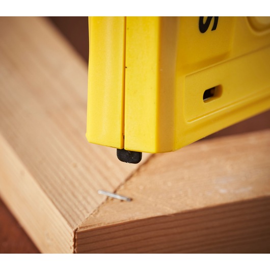 STANLEY 6-TRE550 stapler close-up in use on wooden boards, side angle.
