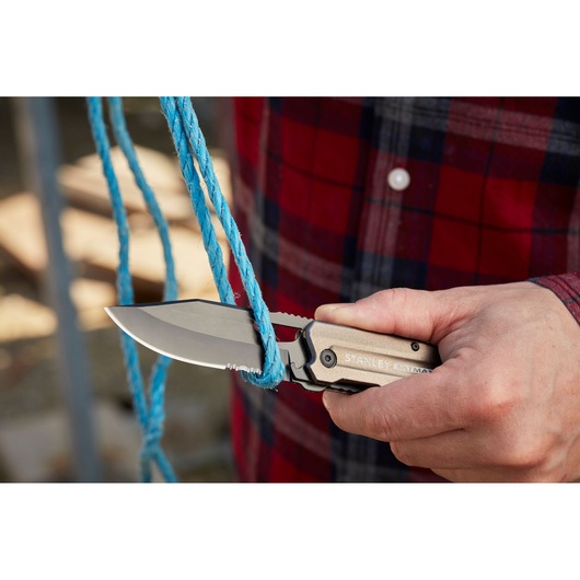 STANLEY FMHT0-10311 folding knife cutting blue rope, close-up outdoor view.