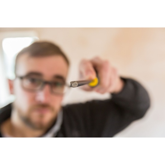 STANLEY FMHT0-62060 screwdriver held in hand, close-up focus on tip with blurred background.