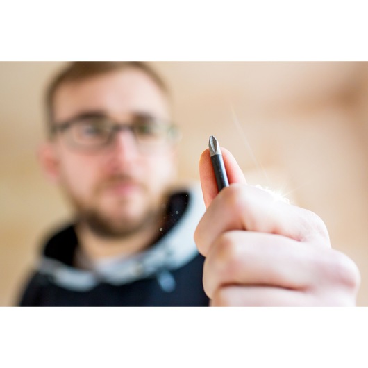 STANLEY FMHT0-62060 screwdriver bit held in hand, close-up photography, blurred background.