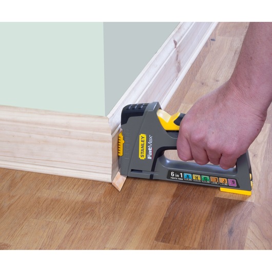 Photo of STANLEY FMHT0-70868 stapler in use attaching trim to wooden floor.