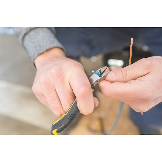Photo of STANLEY FMHT0-80524 diagonal pliers cutting blue wire, product shown in use.