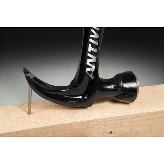 STANLEY FMHT1-51277 claw hammer removing nail from wood, close-up side view.