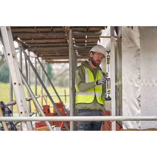 Photo of STANLEY FMHT43673-1 spirit level used by a worker in safety gear on a construction site.