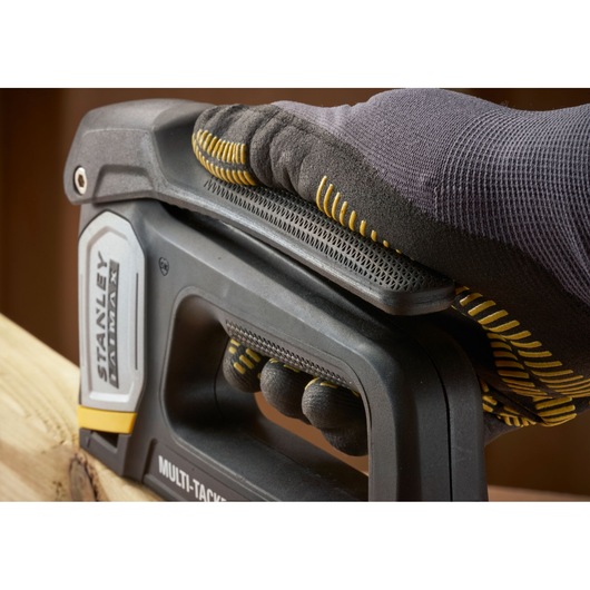 STANLEY FMHT70401-0 stapler held by gloved hand on wood, close-up angle