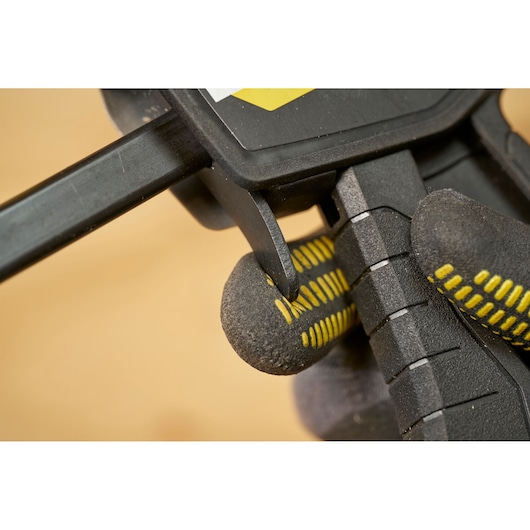 STANLEY FMHT83272-0 clamp handle close-up, black and yellow textured glove, photography.