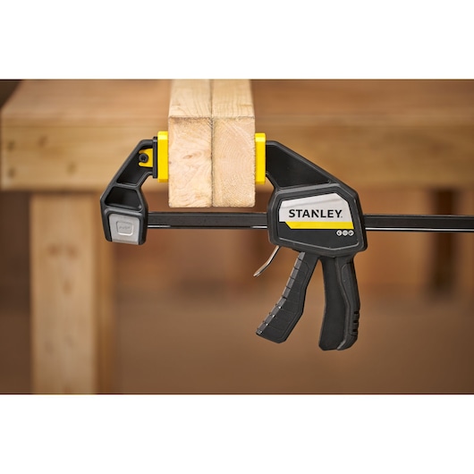 STANLEY FMHT83275-0 quick-adjust bar clamp securing two wooden boards on a workbench.