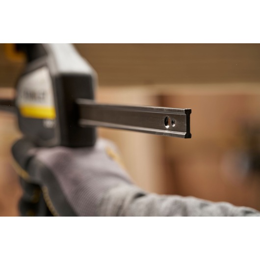 Photo of STANLEY FMHT83275-0 clamp bar in use, closeup shows metal rail and gloved hand.