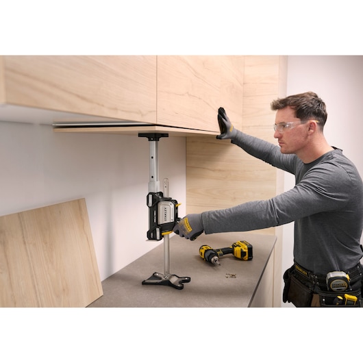 STANLEY FMHT83554-1 cabinet support system holding a wooden cabinet during installation, side angle.