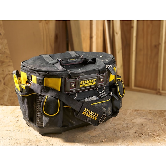 Stanley FMST1-70749 tool bag, black and yellow fabric, FatMax logo, sturdy base, shoulder strap, in workshop.