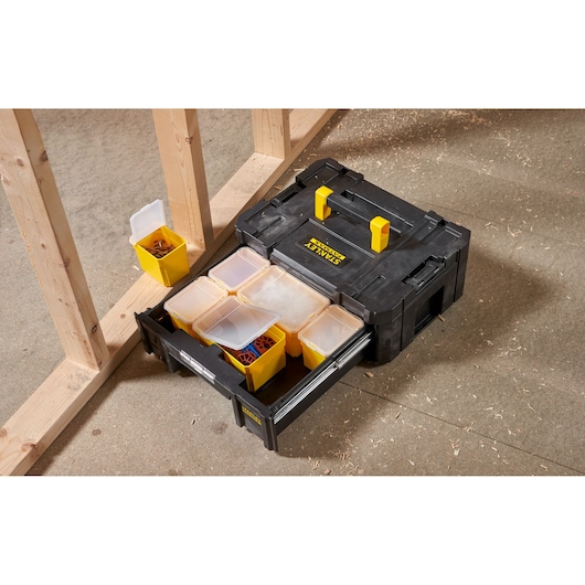 STANLEY FMST1-71968 organizer box with yellow compartments, open drawer, angled view on workshop floor.