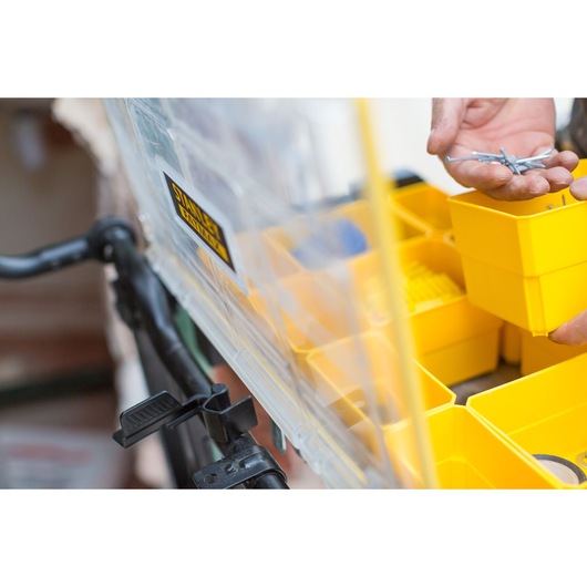 STANLEY FMST1-75678 organizer box close-up with yellow compartments, hand holding nails.