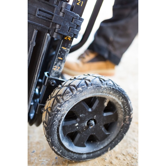 STANLEY FMST1-75683 rugged black wheel close-up on mobile storage cart, outdoor setting.
