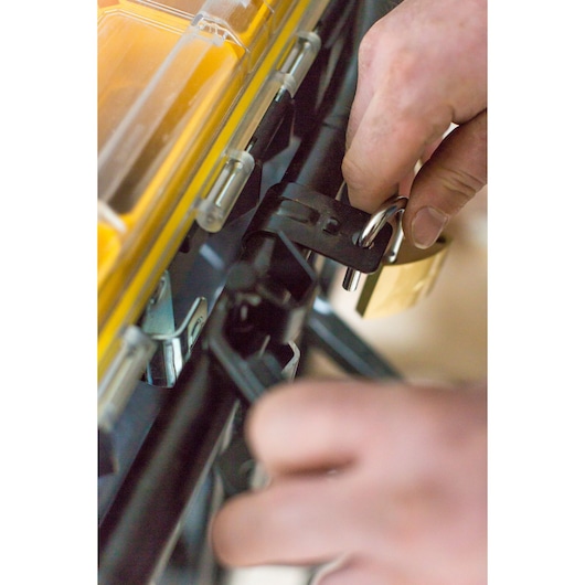 STANLEY FMST1-75683 toolbox close-up with hands locking latch using a padlock, product photography.