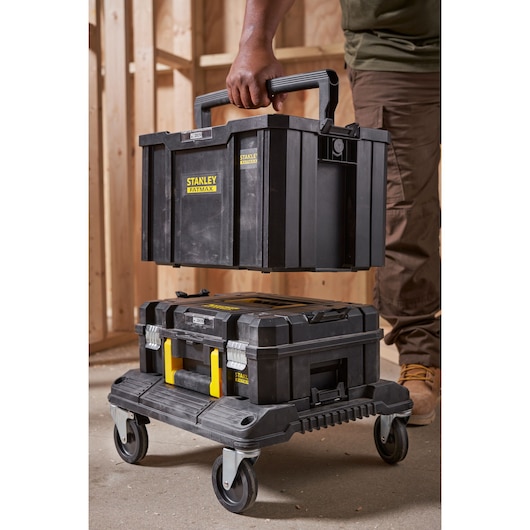 STANLEY FMST1-75794 stackable black toolboxes on wheeled trolley, photo shows handle grip and workshop setting.