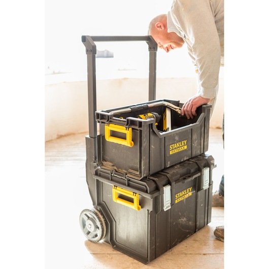 STANLEY FMST1-75798 mobile toolbox system with yellow handles, shown stacked on wheels, in use on jobsite.