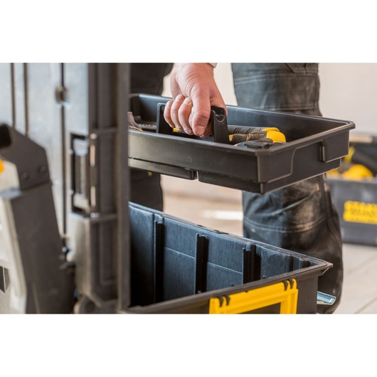 STANLEY FMST1-75798 toolbox with removable tray in use, black and yellow, photo from side angle.