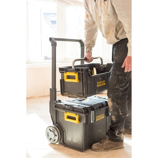 STANLEY FMST1-75798 tool box stack with yellow handles, top box being carried, indoor setting.