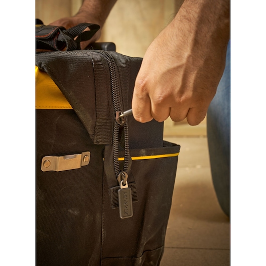 STANLEY FMST1-80148 tool bag with zipper detail and hand using a wrench, close-up photography.