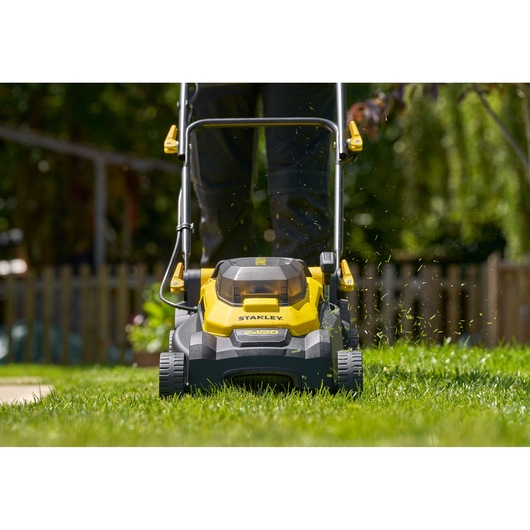 Stanley SCMWP3701N lawn mower front view in use, yellow and black design on a green lawn outdoors.