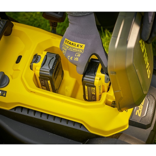 STANLEY SCMWP3701N photography of yellow battery compartment with STANLEY gloves installing lithium batteries