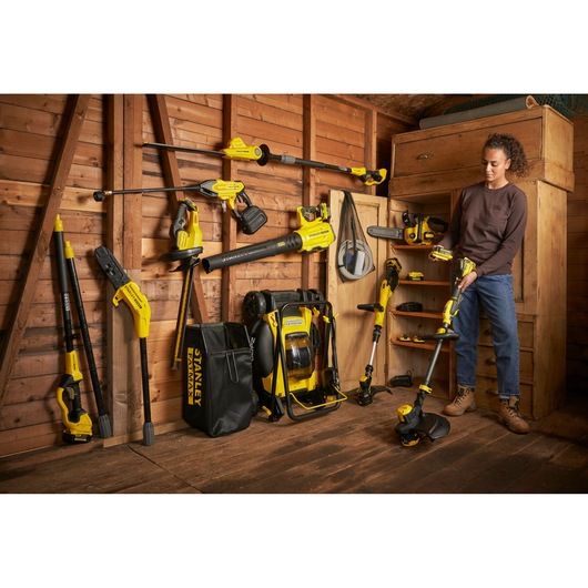 Stanley photography tools and accessories organized in a wooden shed, person holding a yellow tool.