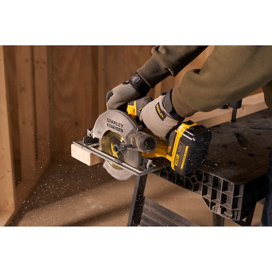 STANLEY SFMCS500M2K circular saw cutting wood, close-up action, yellow and black tool, workshop setting