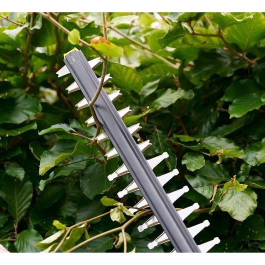 STANLEY STCHT8255M1 hedge trimmer blade close-up with green leaves in background.