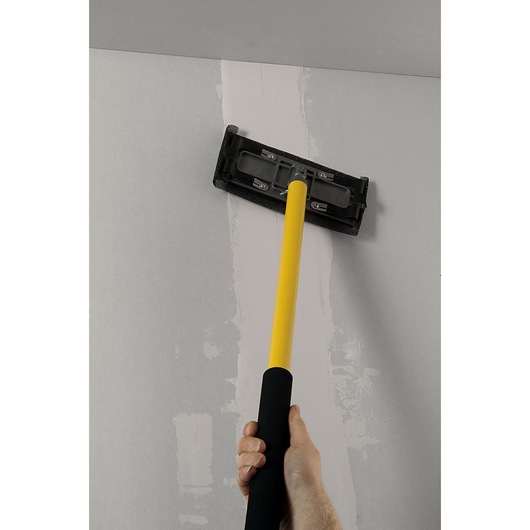 STANLEY STHT0-05928 drywall sander with yellow handle used on ceiling, close-up photography.