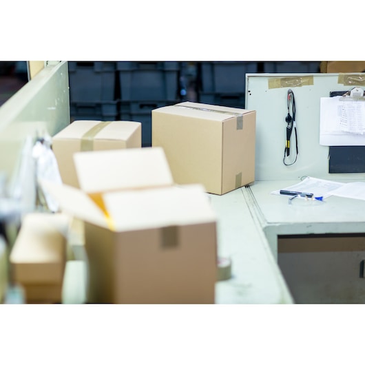 STANLEY STHT0-10293 photography of cardboard boxes on a packing station table, some boxes taped shut.
