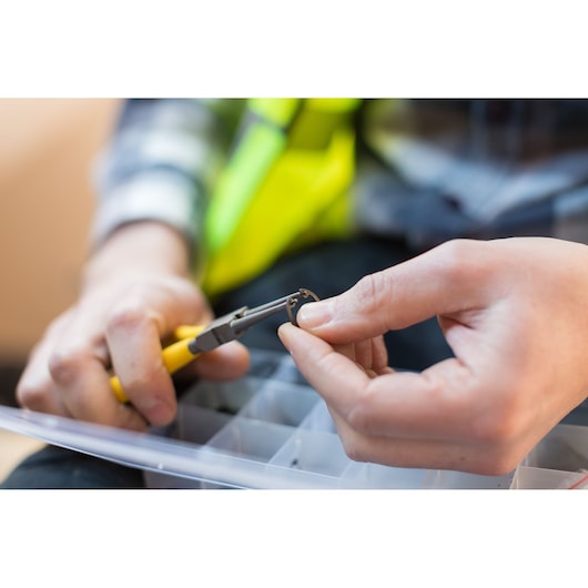 STANLEY STHT0-75411 circlip pliers held in hand, close-up photography, yellow handle, tool in use.