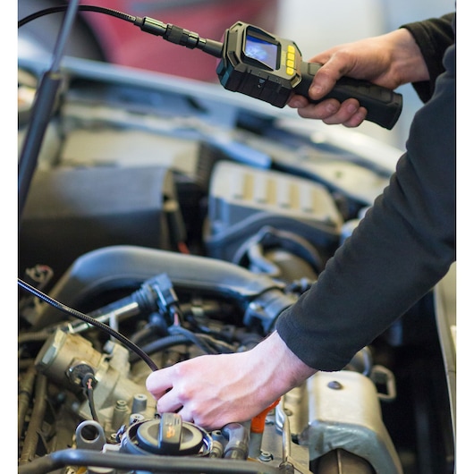 Photo of STANLEY STHT0-77363 inspection camera used by a person examining a car engine.