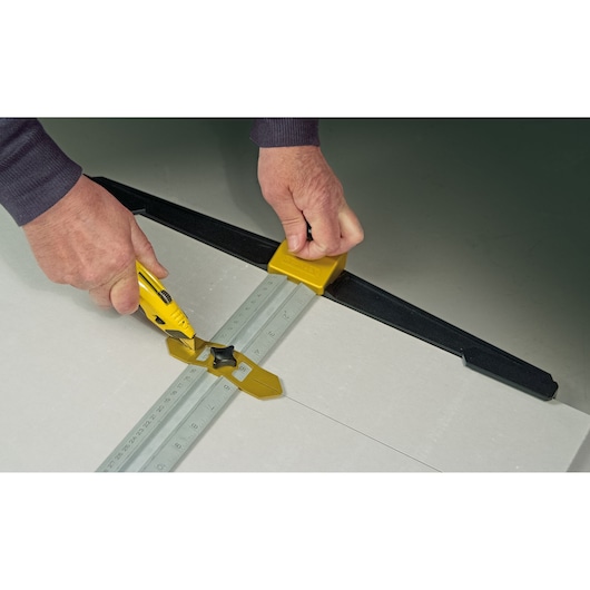 STANLEY STHT1-05933 drywall T-square being used to guide a utility knife for straight cuts on drywall sheet.